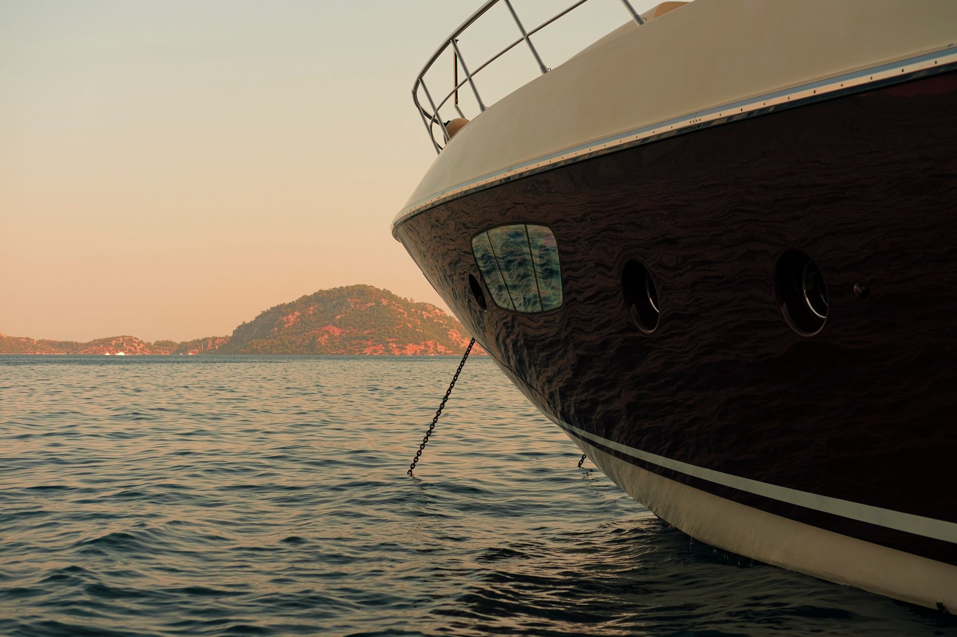 Motor mega yacht at anchor, front view at sunset seascape during luxury holiday